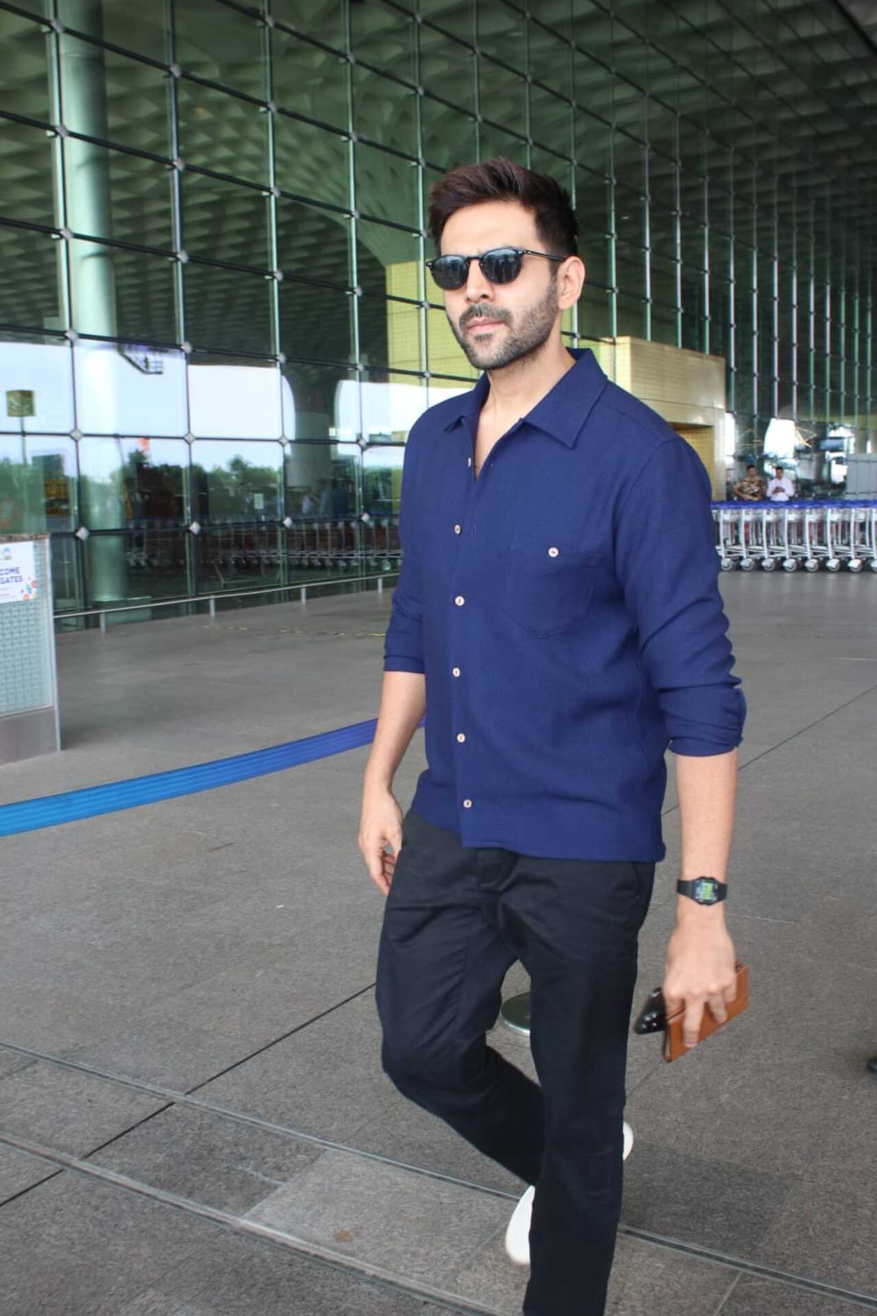 Kartik Aaryan was seen at the Mumbai airport today. He opted for a blue shirt and black pants. The actor sported a sharp look as he is busy shooting for Chandu Champion